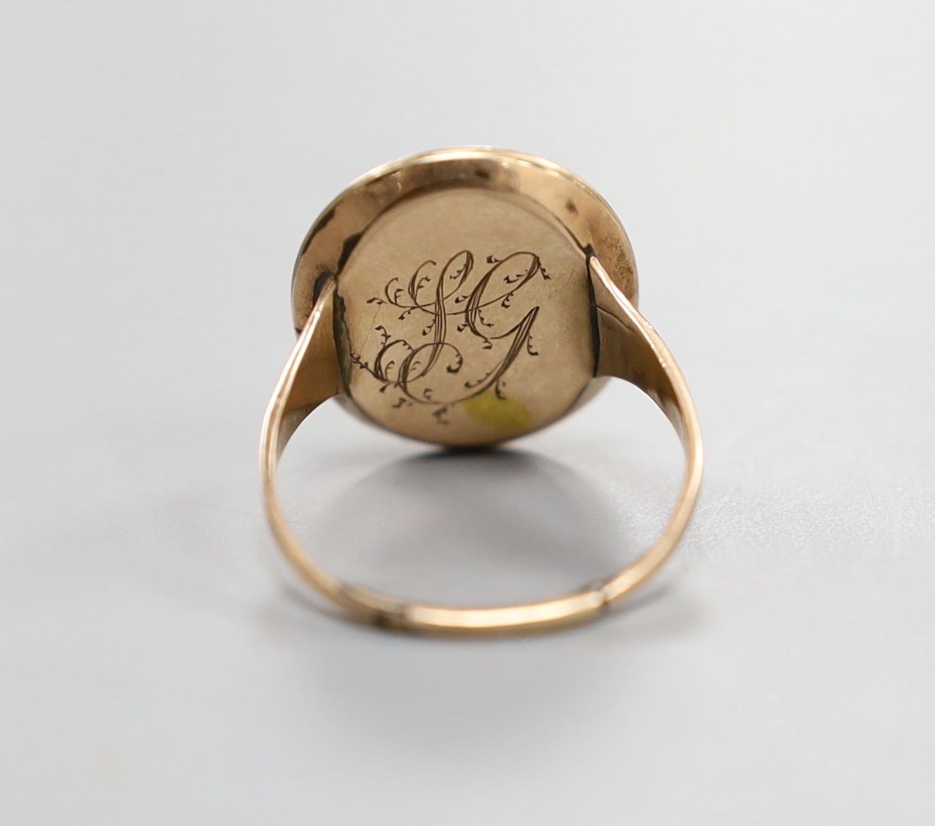An early 19th century yellow metal ring inset with ivory? panel of a young lady